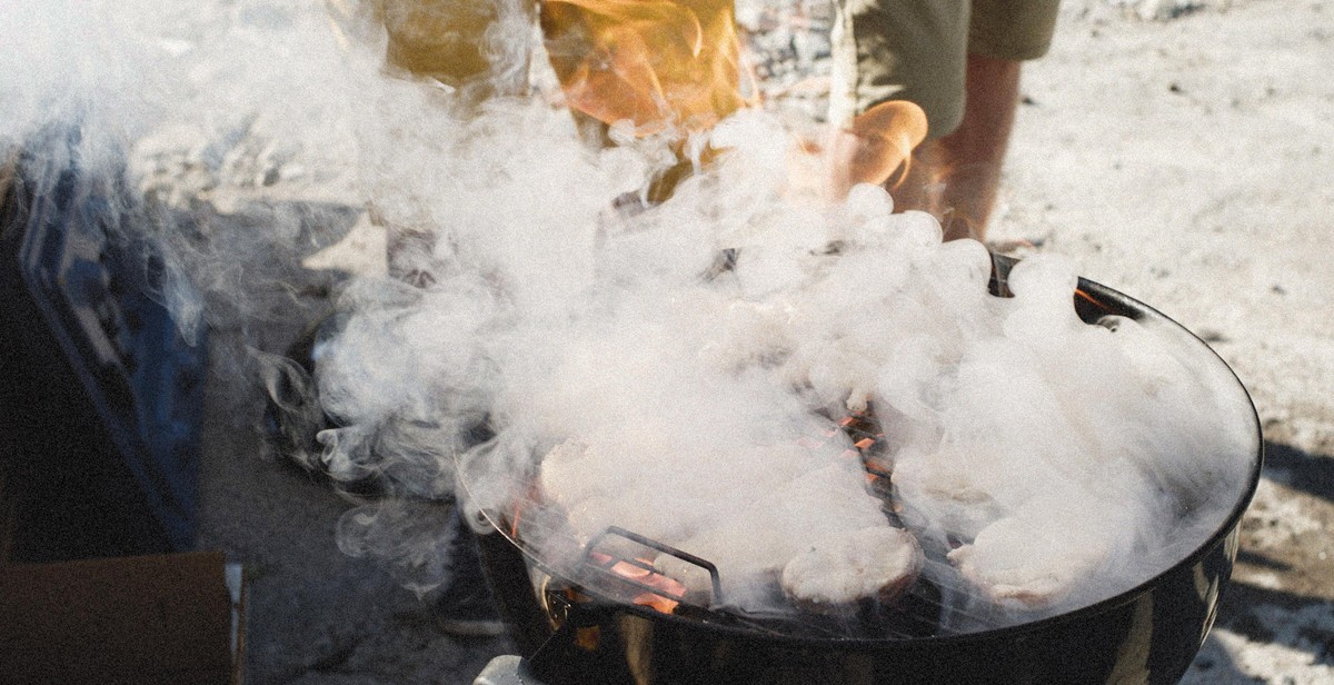 preparing ribs for smoking on a charcoal grill